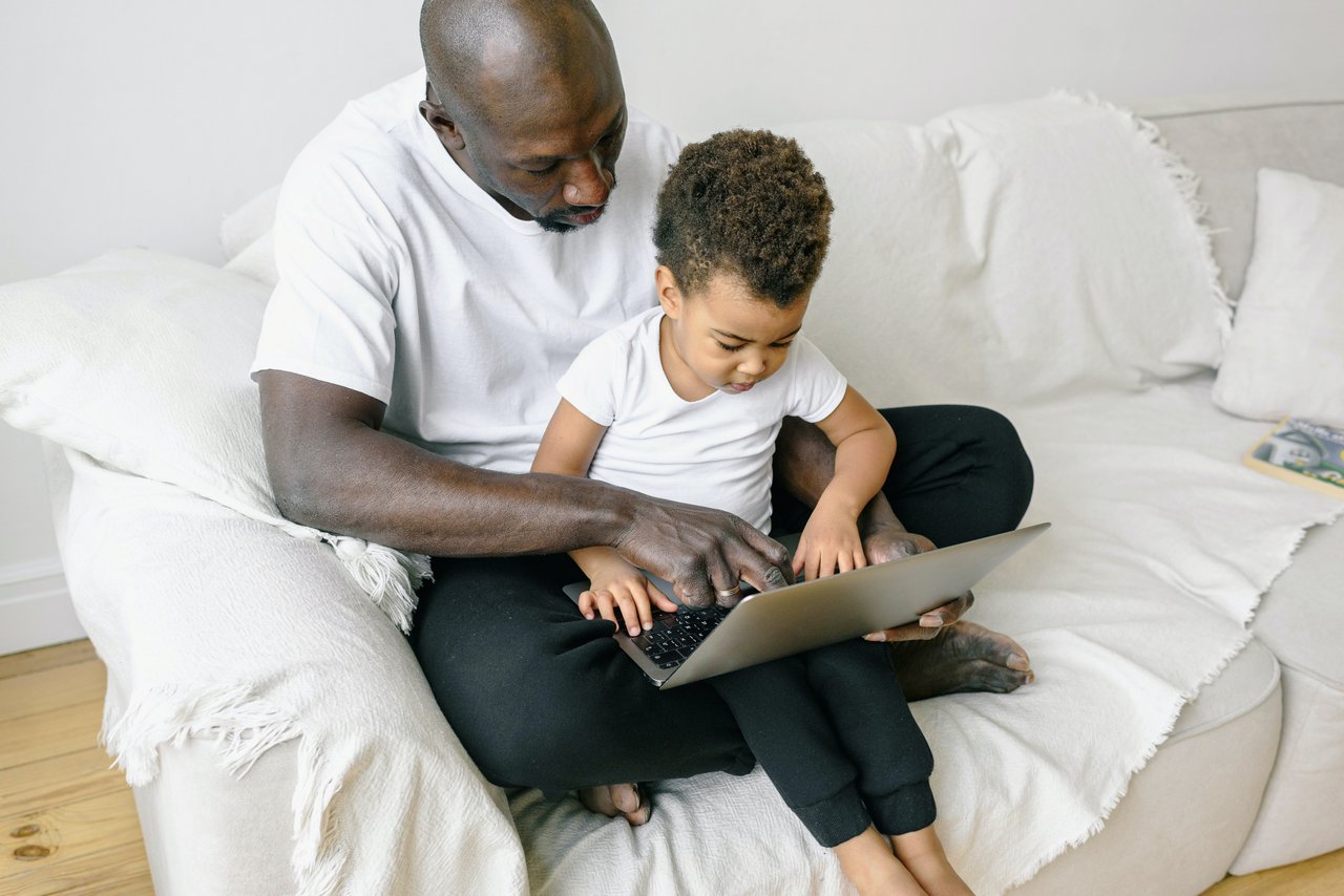 Father and son learning about something on the computer together.