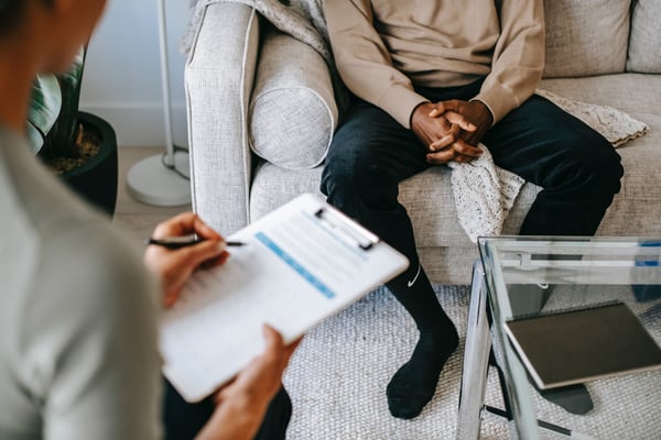 person sitting across the room from a therapist