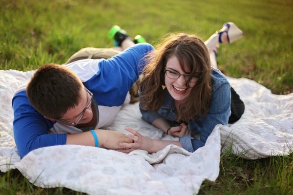 couple on a blanket smiling and laughing
