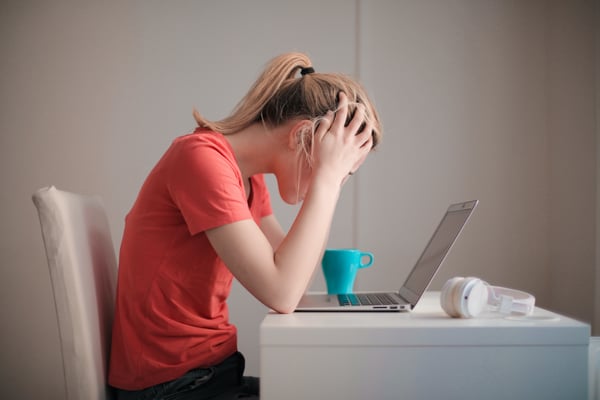 stressed college student in front of a laptop