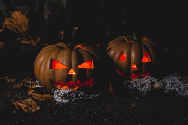 Two jack-o-lanterns carved from pumpkins for halloween 2022