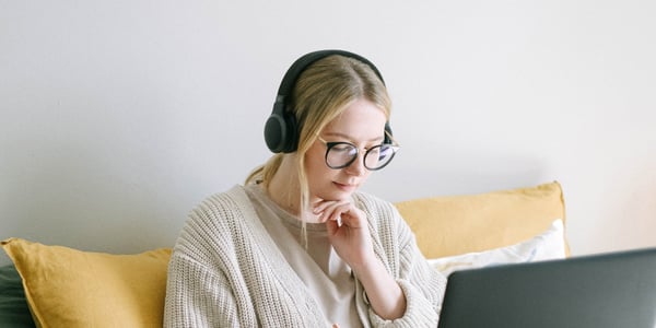 Black headphones over the letters "ADHD" with a soft orange background