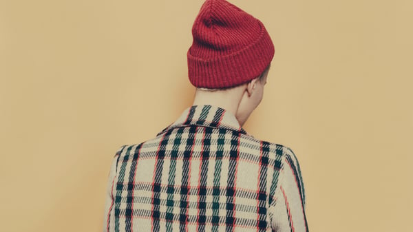 The back of a person's head. They are wearing a hat to hide bald spots caused by trichotillomania or hair pulling.