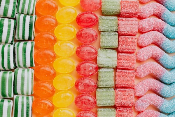 A close-up photo of colorful candy in green, orange, yellow, red, and blue.
