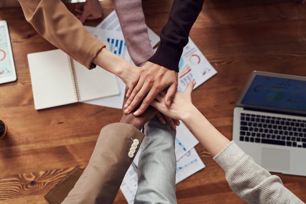 A group of colleagues put their hands in for a team break.