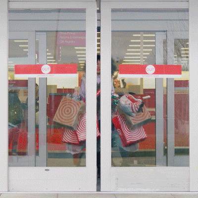 gif of a woman smiling while walking out of Target with a bunch of bags