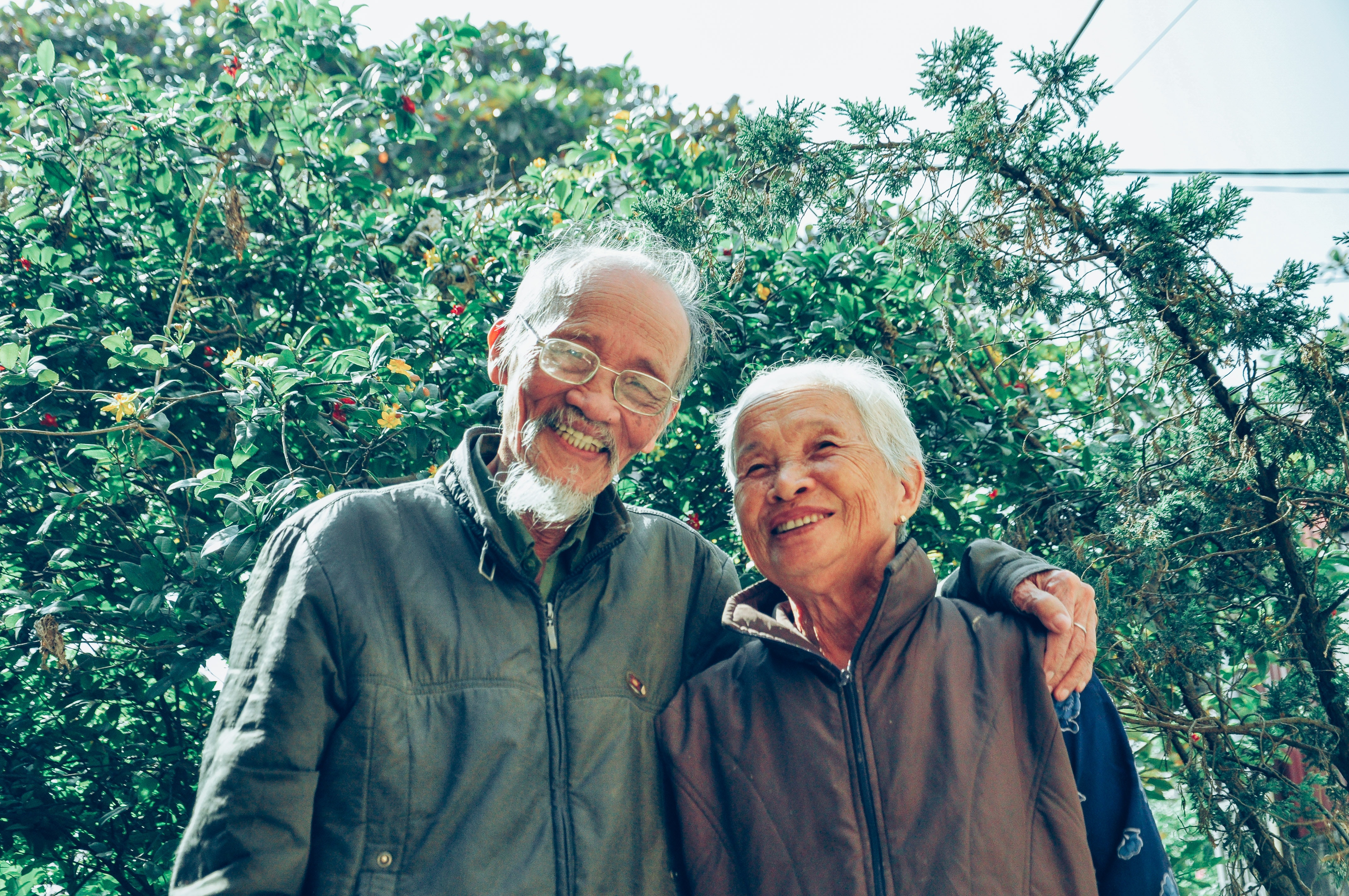 an elderly asian couple smiling next to each other
