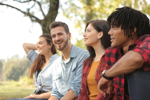 a diverse group of friends sitting outside together