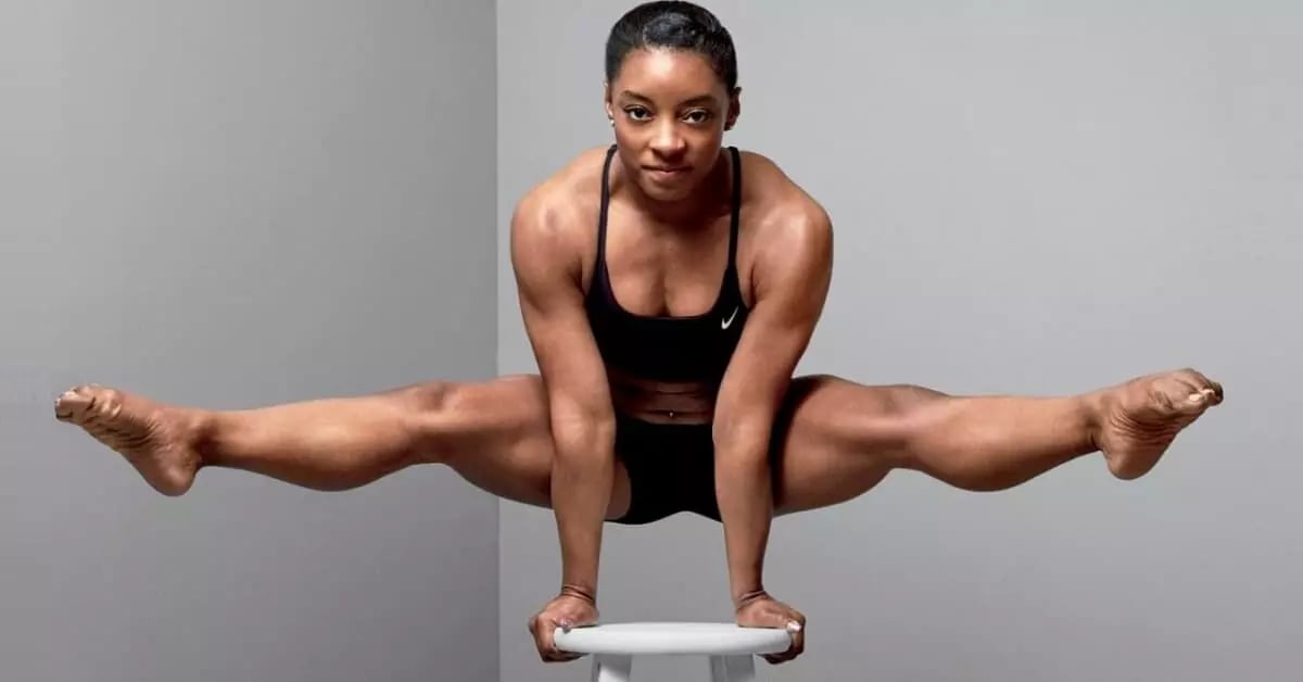 photo of gymnast simone biles holding herself up on a stool