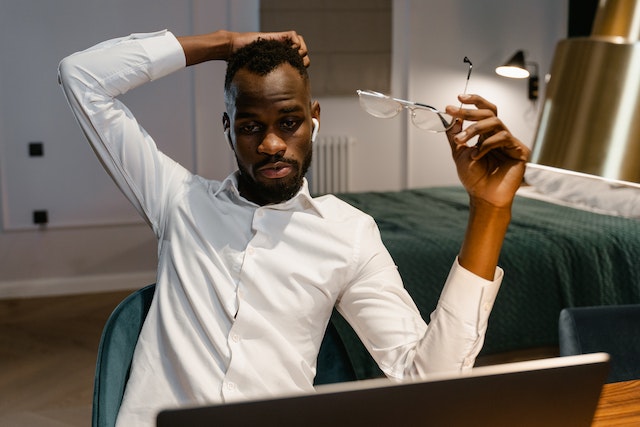 a man sitting at his desk and staring off into space from burnout and brain fog.