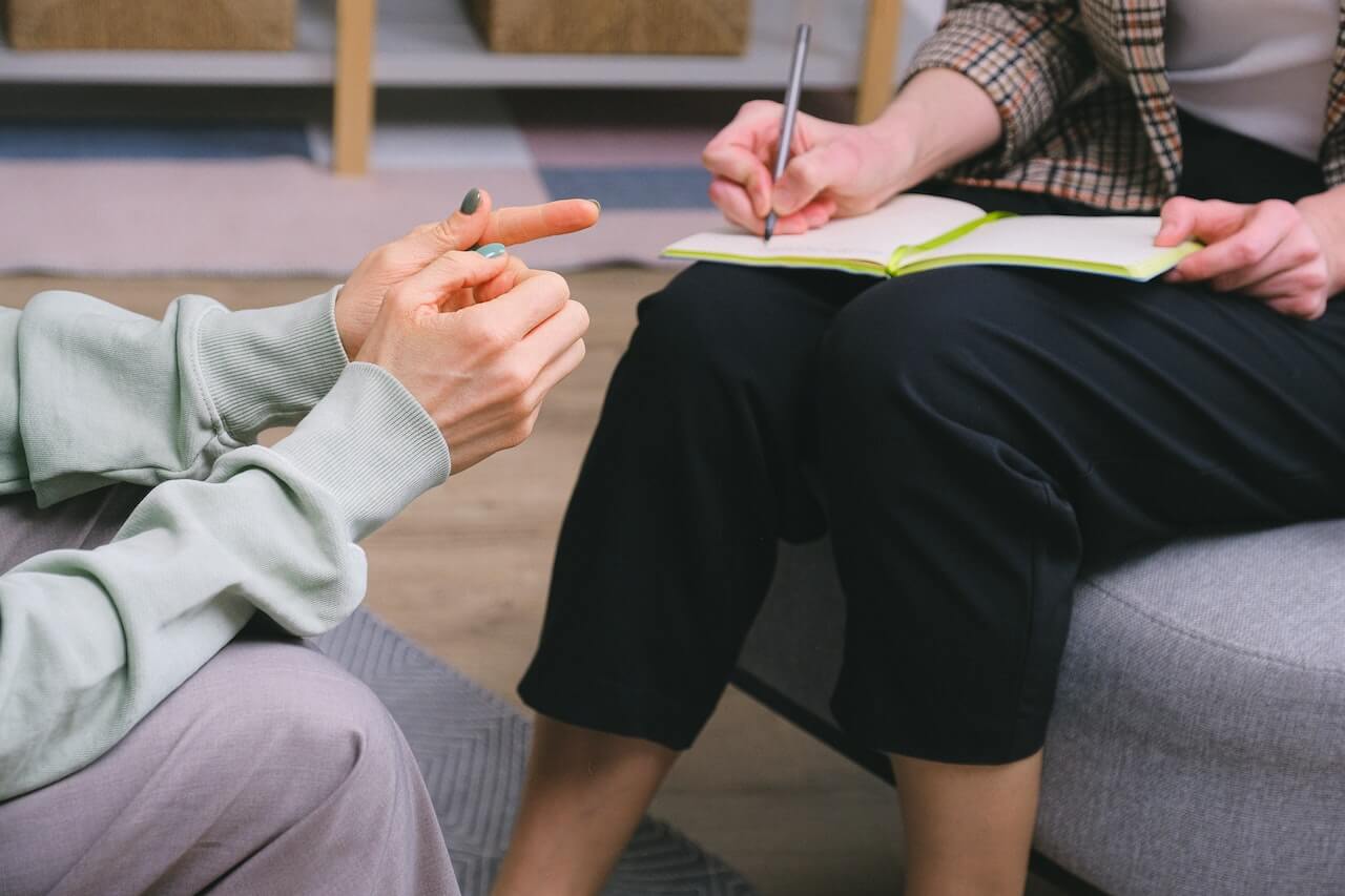 A woman with ADHD and SPD sits with a therapist to talk about sensory integration therapy