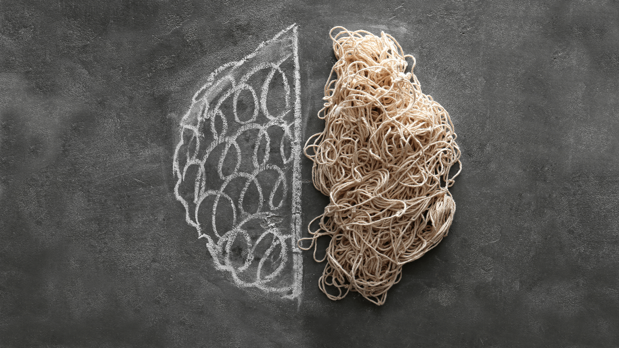 A chalkboard background with a drawing of a brain on the left side. The right side of the brain is made out of jumbled string.