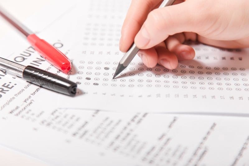 This is a zoomed in image of a hand holding a pencil filling in answers on a test