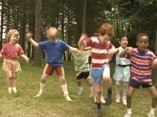 GIF of a group of children from a 90’s television show dancing wildly in nature.