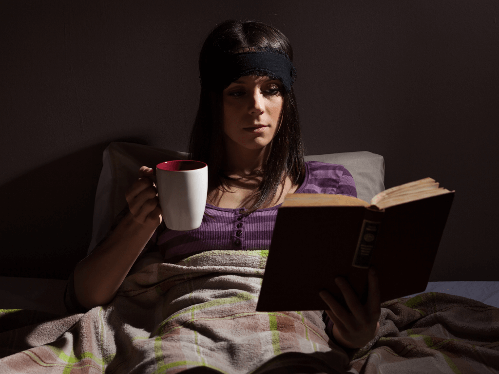 ADHD bedtime routine, showing a woman with adhd reading a book and sipping caffeine free tea before bed for her new sleep routine to help her feel less tired throughout the day