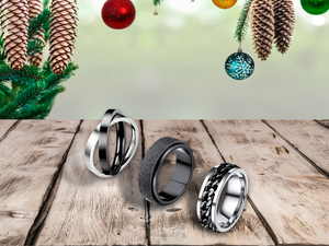 Fidget spinning rings on a wooden table with a christmas tree and ornaments in the background